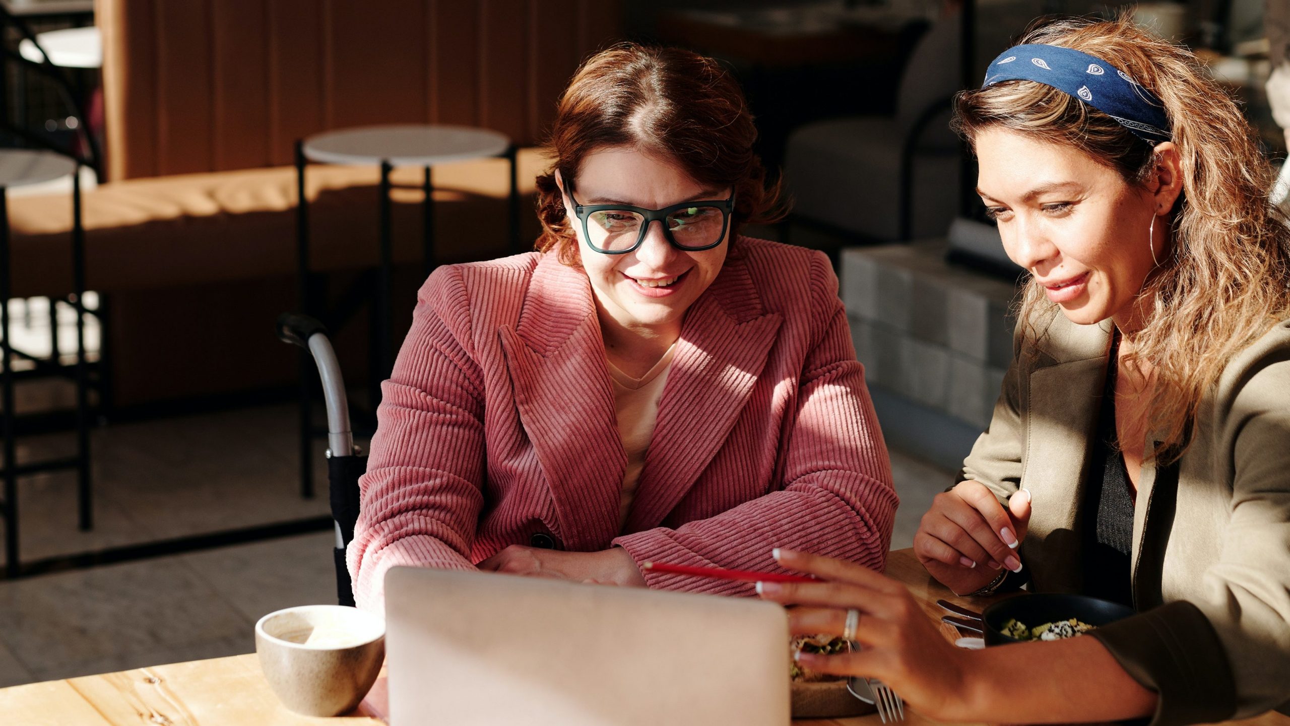 Duas mulheres olhando atentamente para a tela de um computador